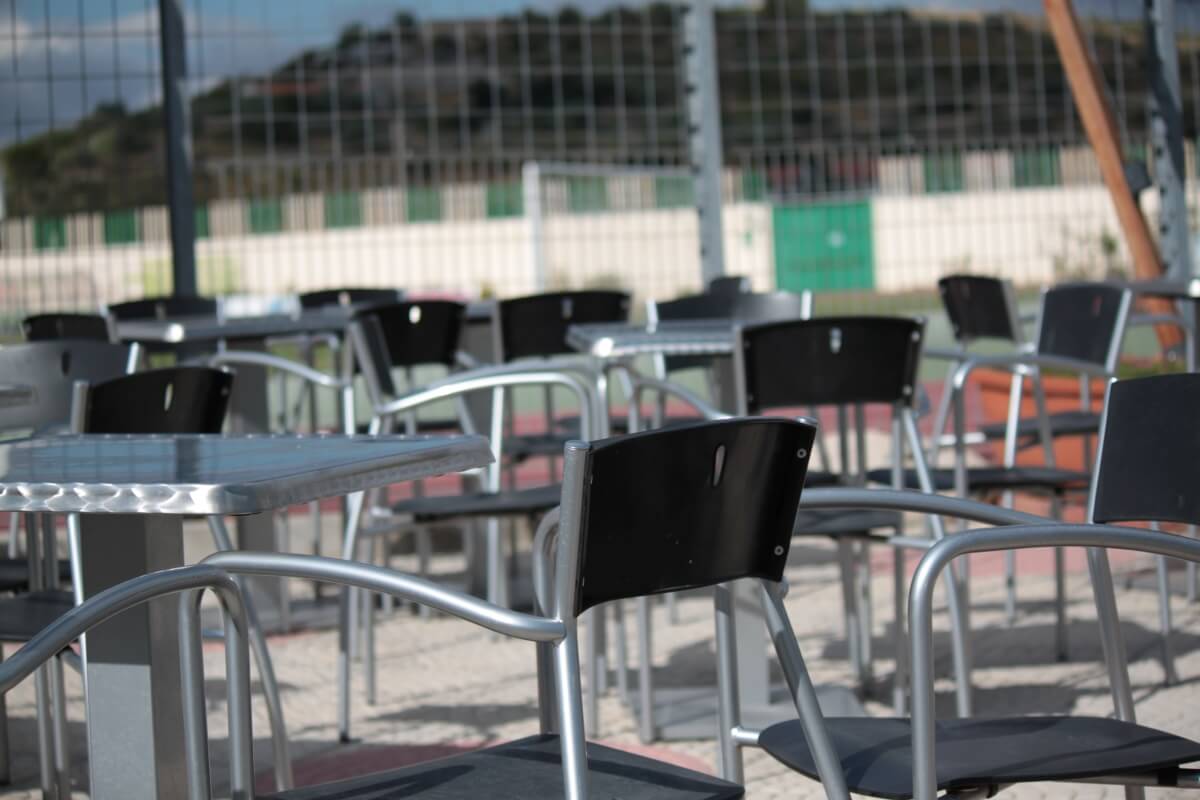 Widok na krzesła ogrodowe metalowe przy stolikach na zewnątrz.